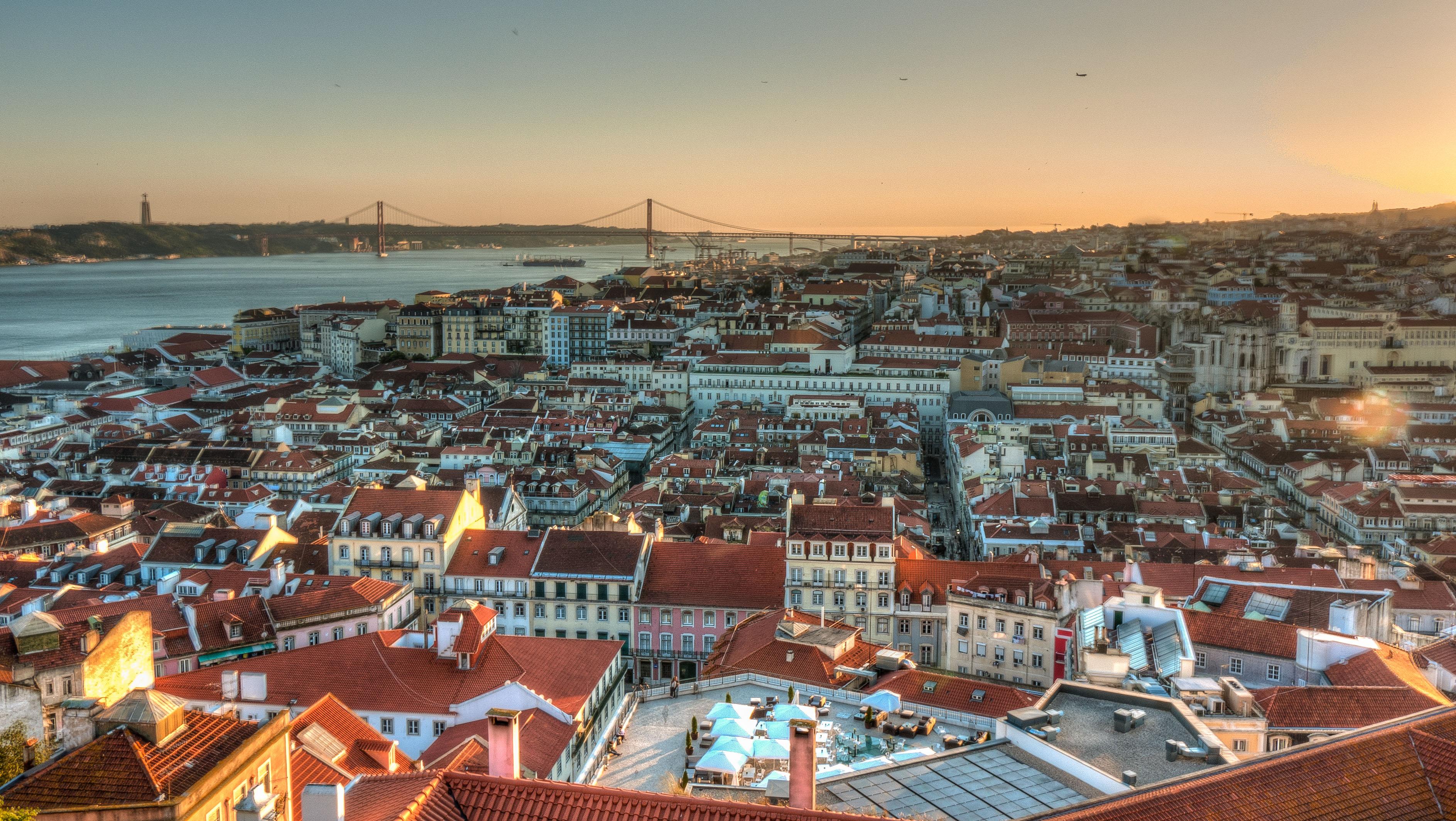 Fotografia área de Lisboa ao entardecer com tons de azul e laranja