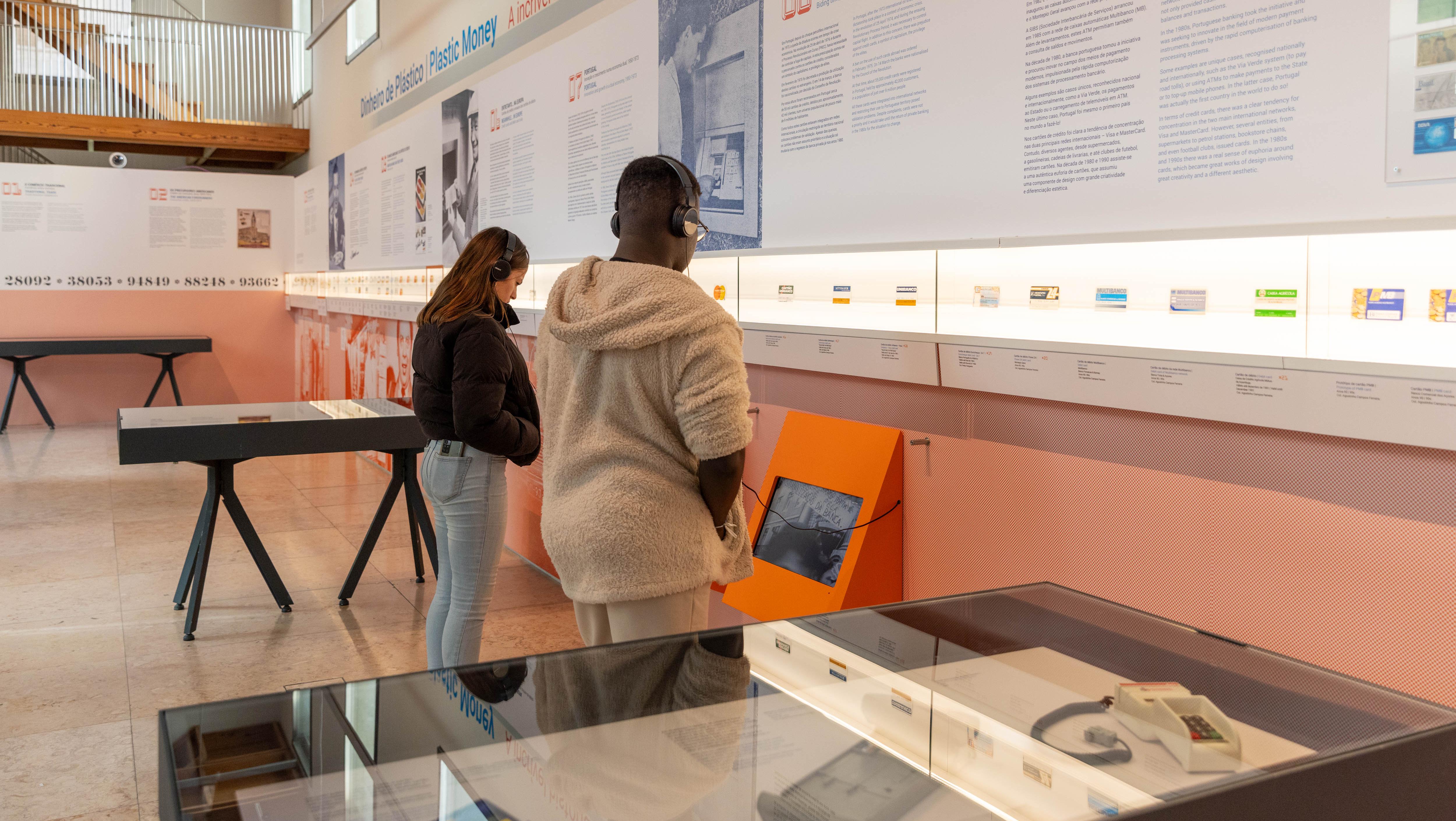 Duas pessoas assistem a um vídeo na exposição