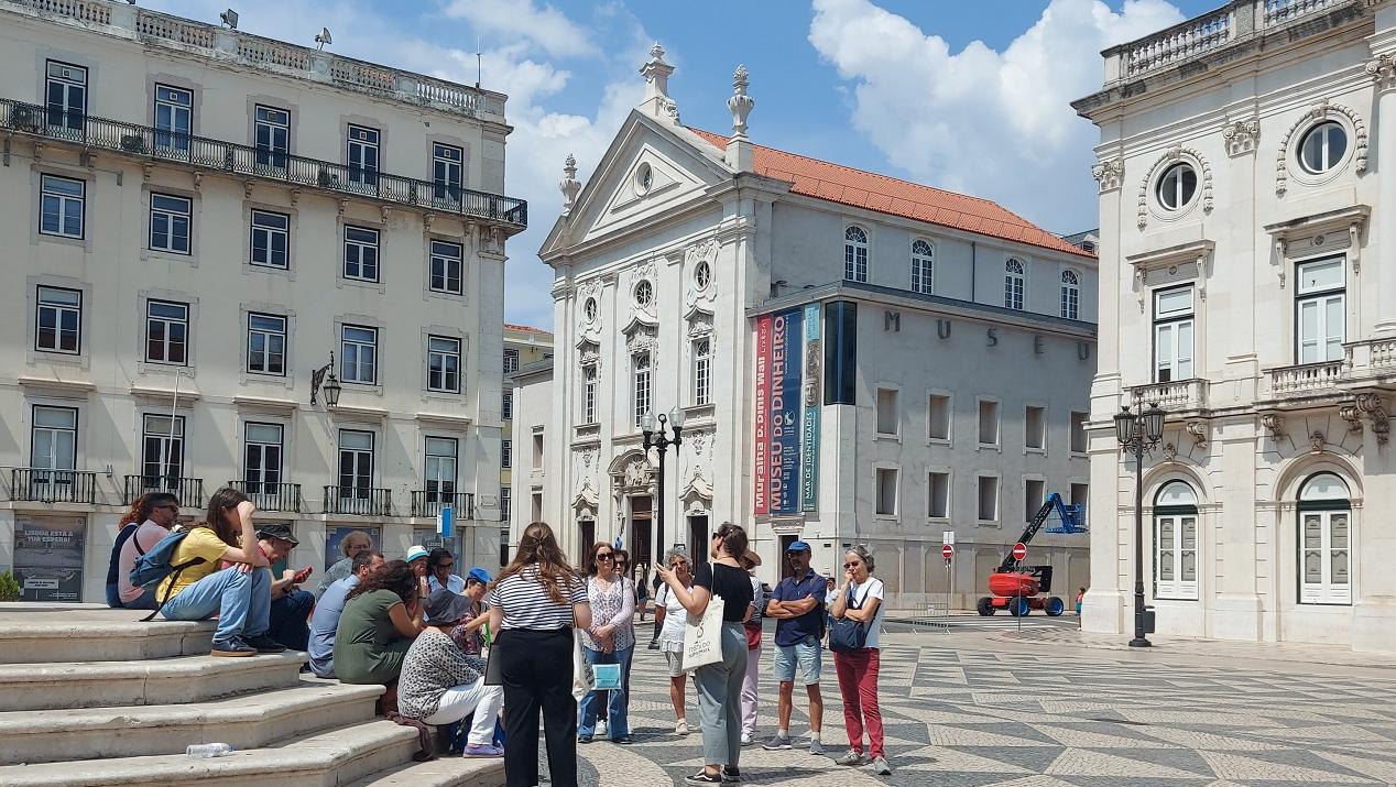 Grupo de pessoas na Praça do Município participa numa visita