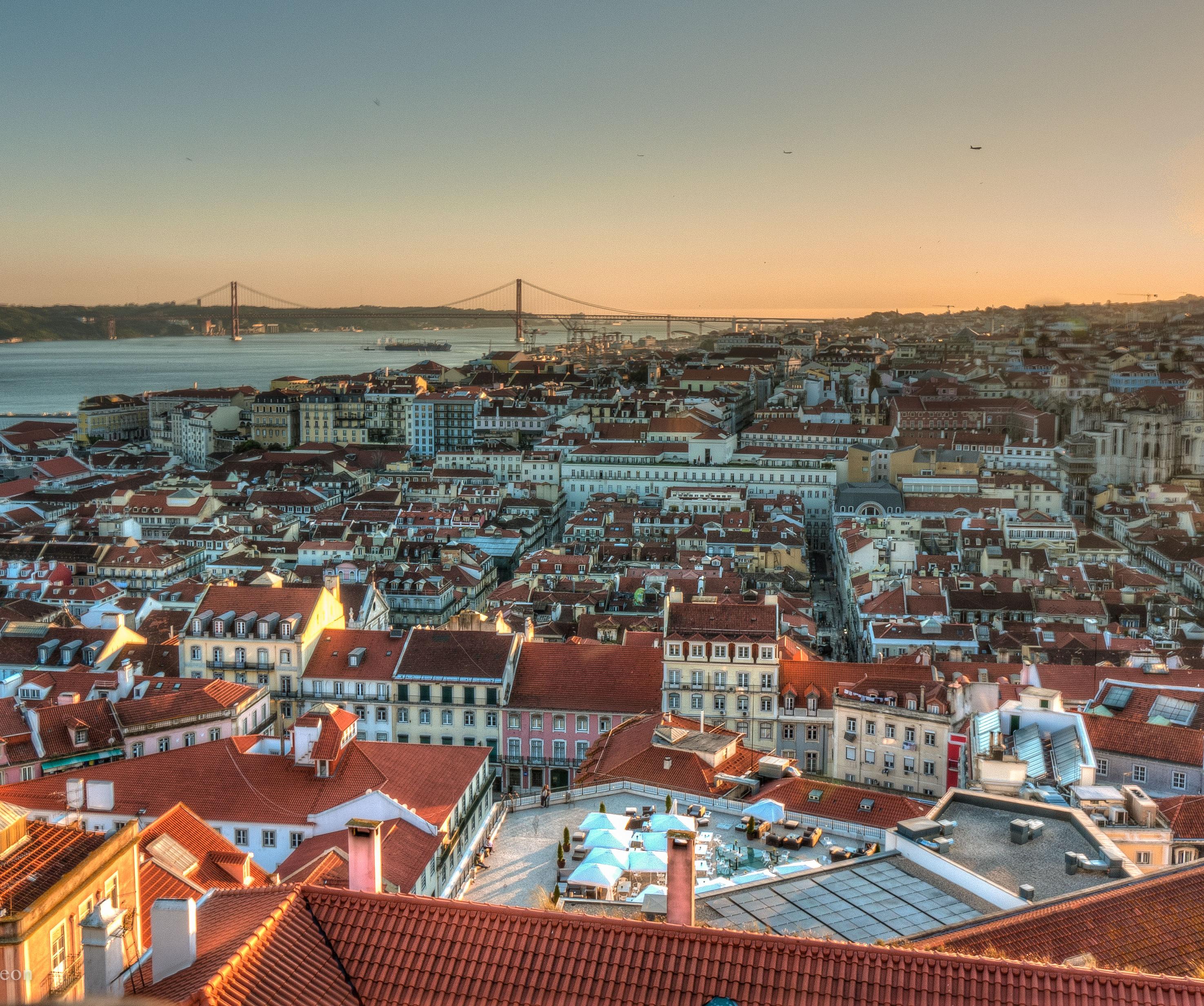 Fotografia área de Lisboa ao entardecer com tons de azul e laranja