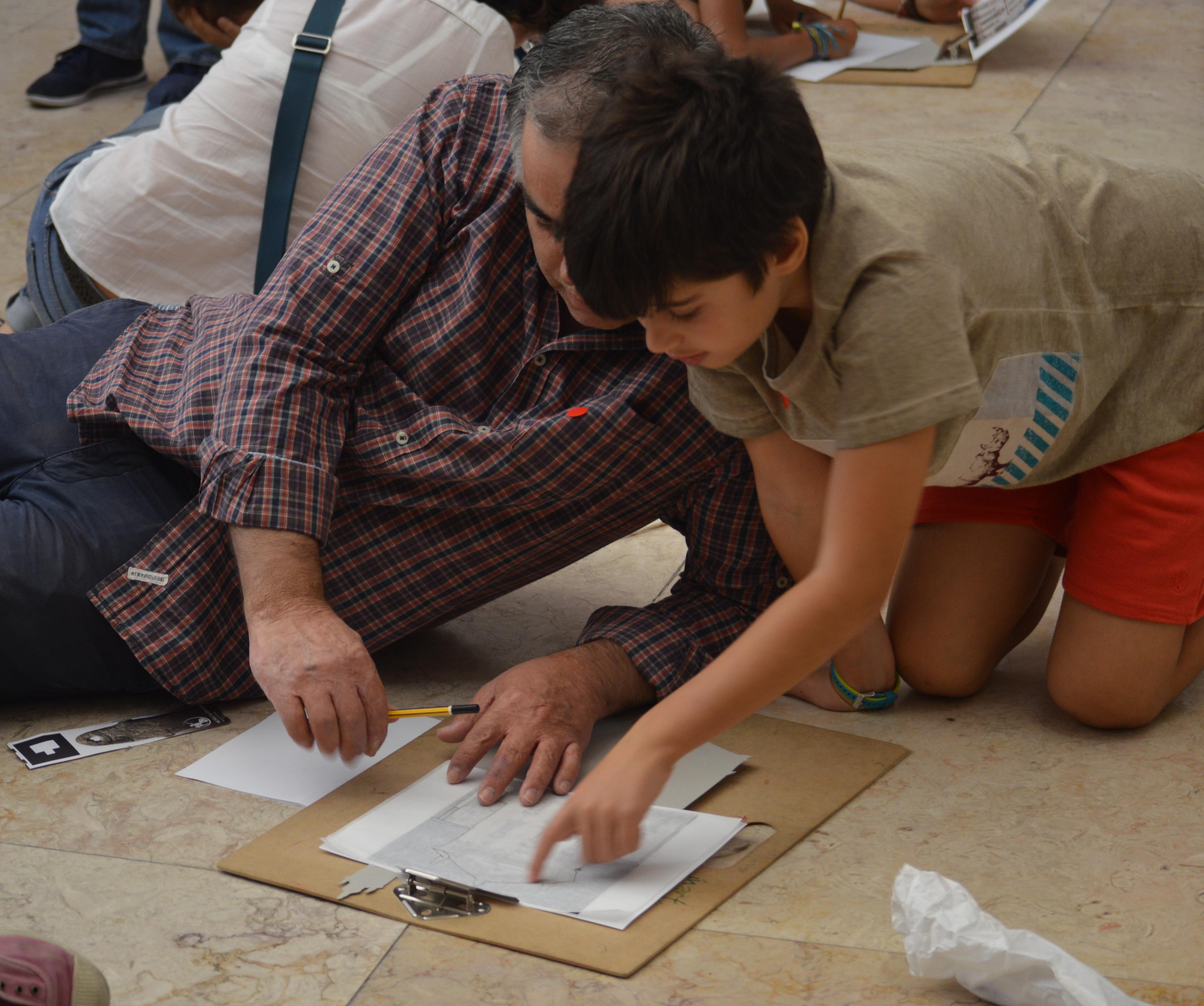 Adulto e criança participam na atividade "Arquitetar ideias" e fazem desenhos sob uma prancheta
