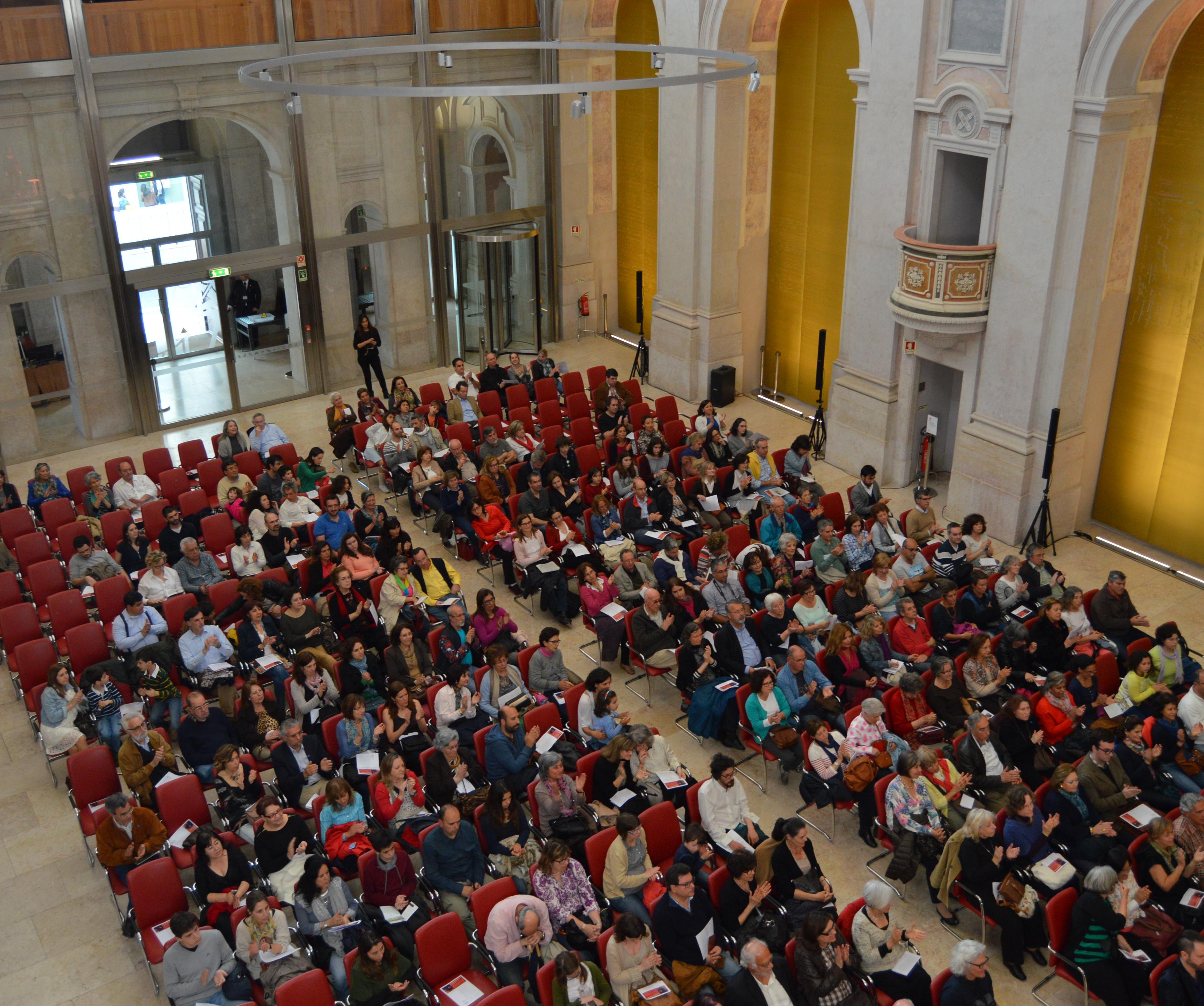 Pessoas sentadas na plateia assistem a concerto de música na nave da antiga igreja de S. Julião